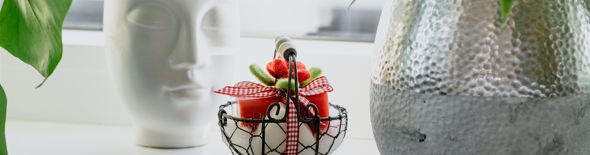 Geschenkartikel kleiner Korb mit Geschenk rote Masche Töpfe auf Fensterbank grüne Pflanze in Topf mit Gesicht Geschenkartikel kleiner Korb mit Geschenk rote Masche Töpfe auf Fensterbank grüne Pflanze in Topf mit Gesicht