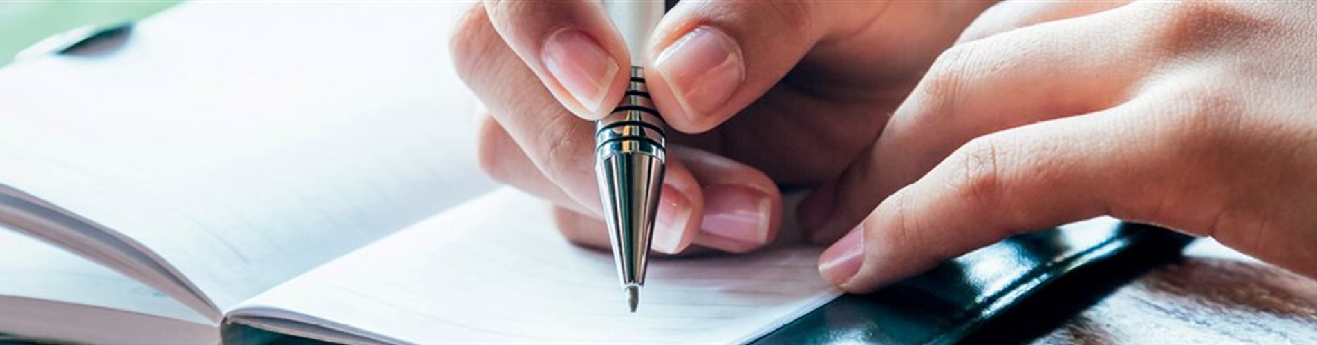 Person, die Notzien in ein kleines Heft schreibt Person, die Notzien in ein kleines Heft schreibt